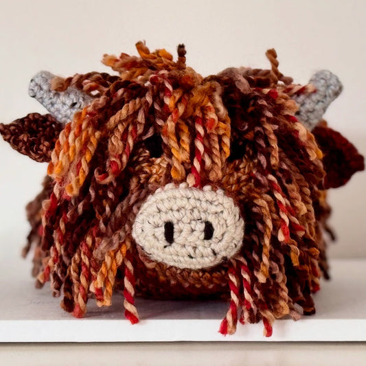Close-up of the handmade crochet Highland Cow doorstop showing its detailed stitching and soft wool finish.