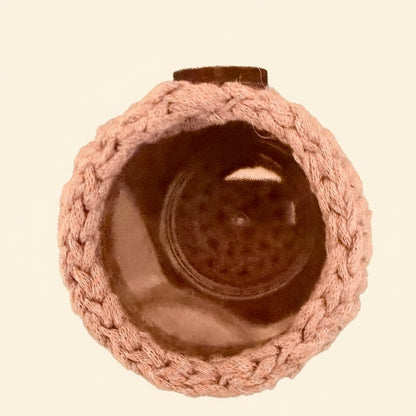 Inside of a hand crocheted storage pot in light pink, showing the interior acrylc pot.