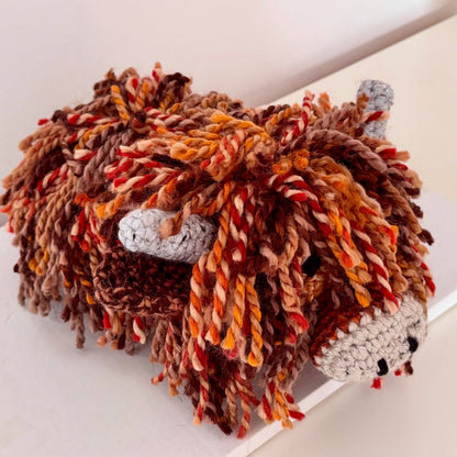 Side view of a handmade Highland Cow doorstop showing its wool texture and handcrafted detail.