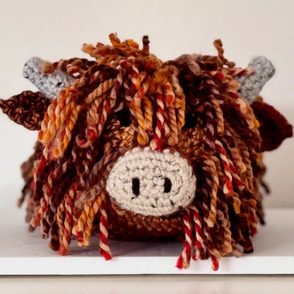Close-up of the handmade crochet Highland Cow doorstop showing its detailed stitching and soft wool finish.